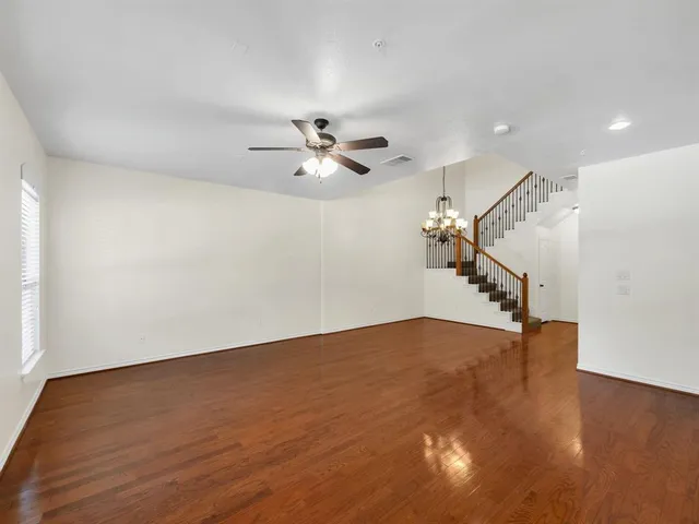 a view of a room with wooden floor and ceiling fan