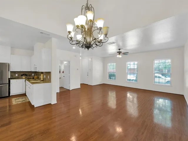 a view of a room with chandelier and wooden floor