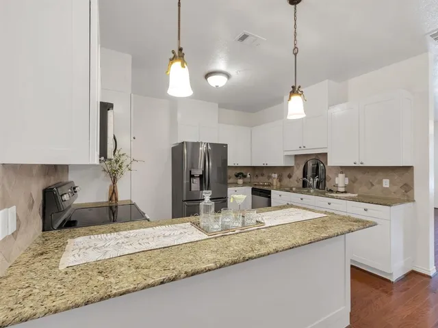 a kitchen with kitchen island granite countertop a sink a counter and cabinets