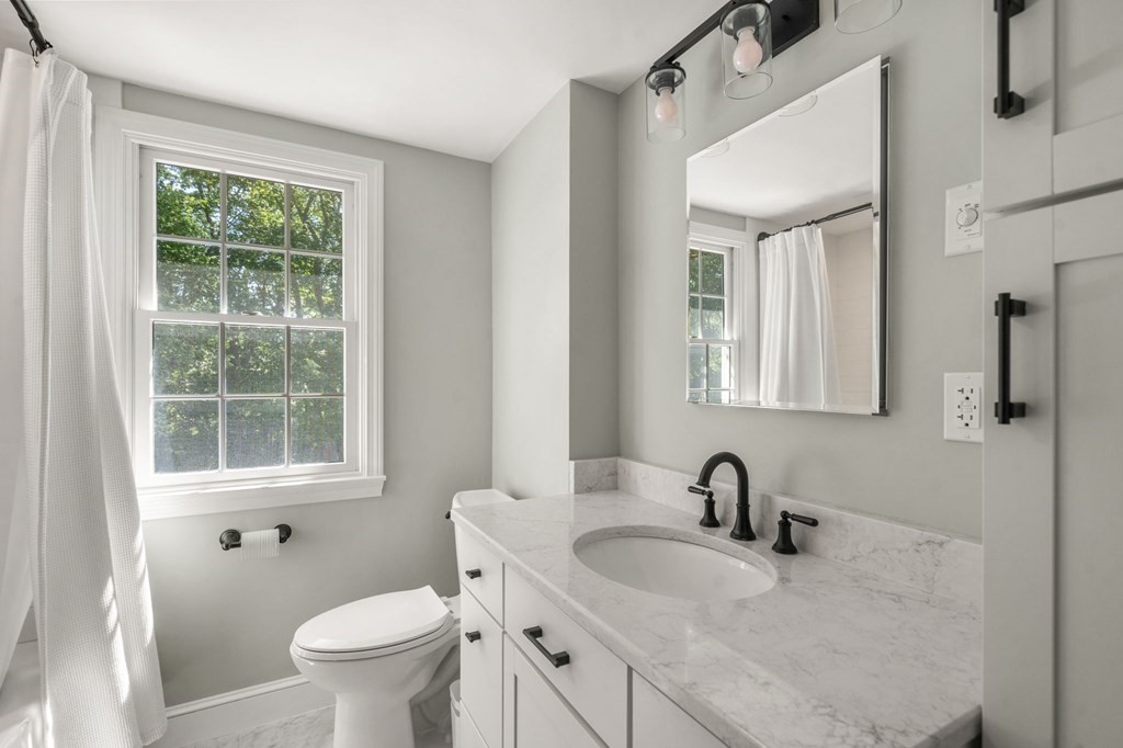 14 Sassamon Road Scituate, MA 02066 - Photo 13 of 28 a bathroom with a granite countertop sink toilet and a mirror