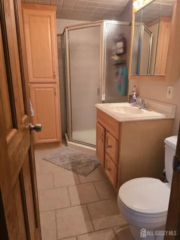a bathroom with a granite countertop toilet sink and mirror