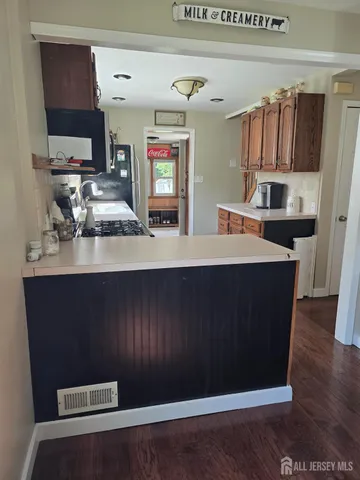 a room with kitchen island granite countertop wooden cabinets a sink and dishwasher
