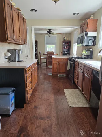a kitchen with stainless steel appliances granite countertop a stove a sink dishwasher and a refrigerator with wooden floor