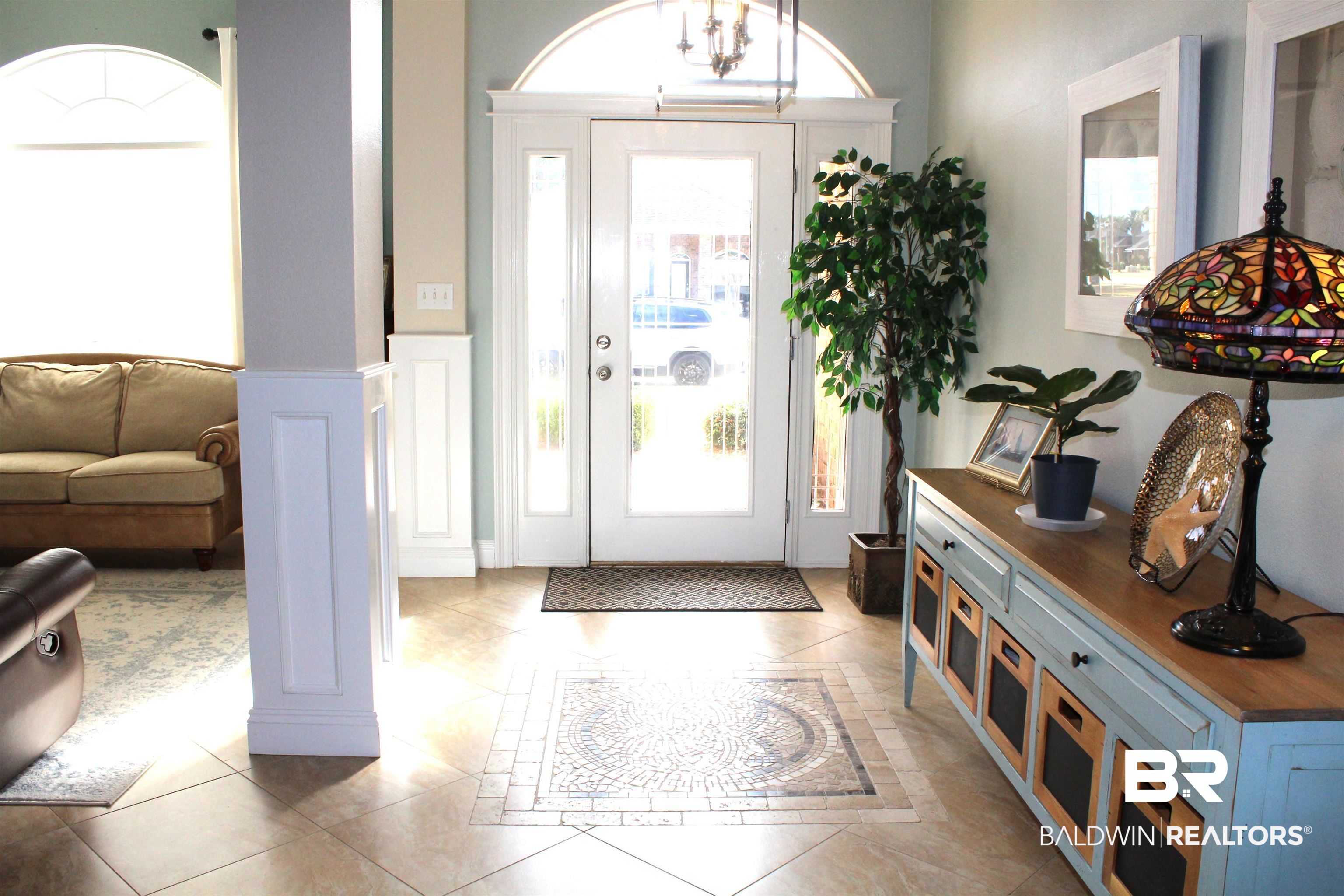 373 Collinwood Loop Foley, AL 36535 - Photo 2 of 49 Entryway featuring a decorative tile inlay, a glass-paned door with an arched transom, and sidelight windows