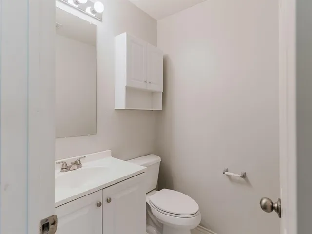 a bathroom with a sink a toilet and vanity