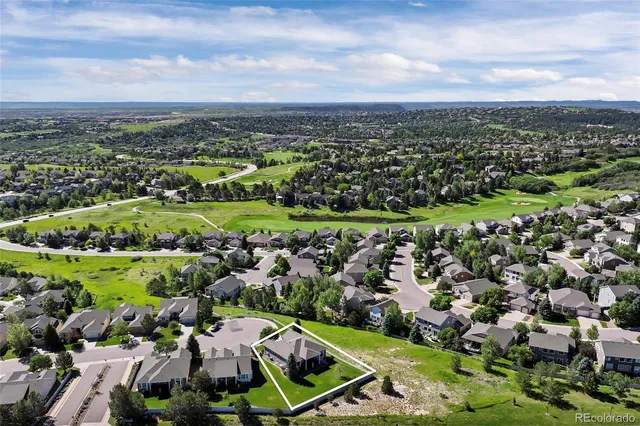 a view of a house with a yard potted plants and a table