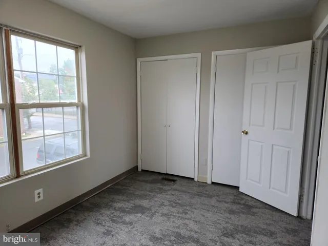 an empty room with windows and closet
