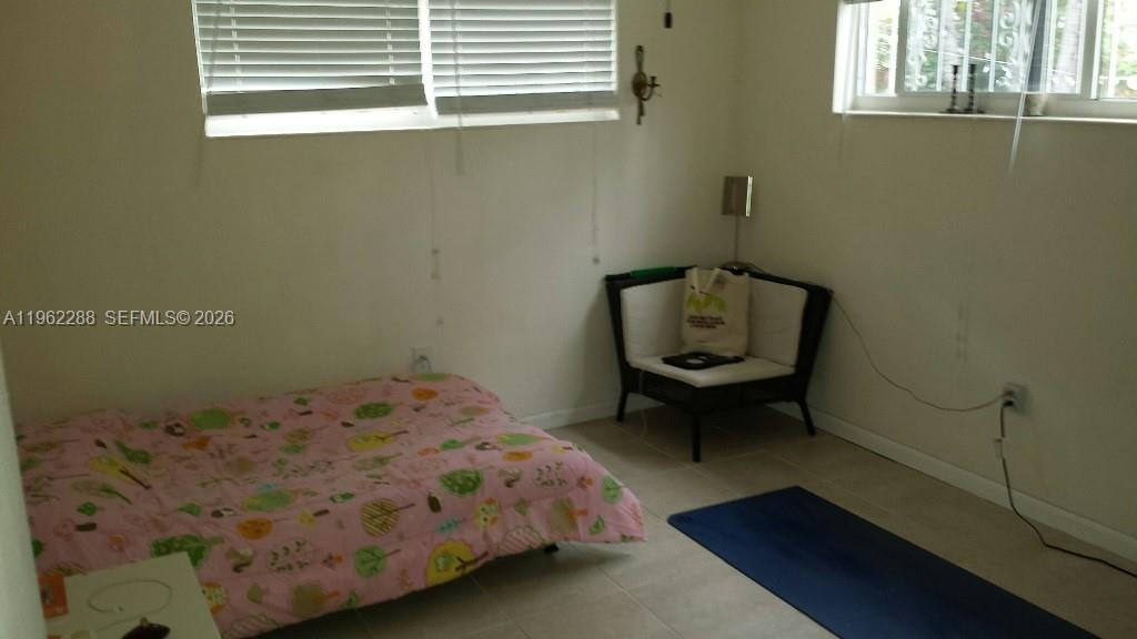 49 Northeast 44th Street Miami, FL 33137 - Photo 5 of 6 a bedroom with a bed and chair