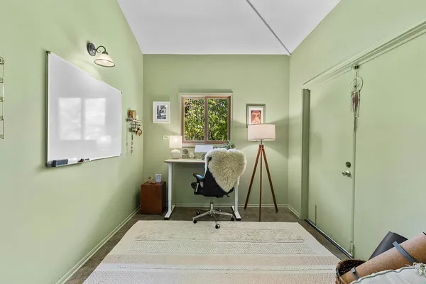 a view of a workspace with furniture and a window