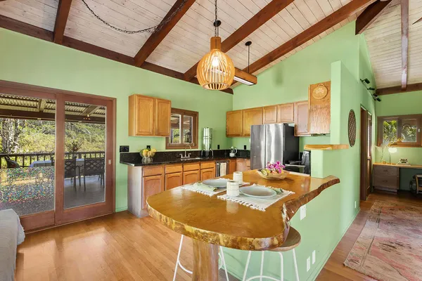 a dining room with furniture a kitchen view and a chandelier