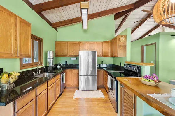 a kitchen with stainless steel appliances granite countertop a sink and a refrigerator