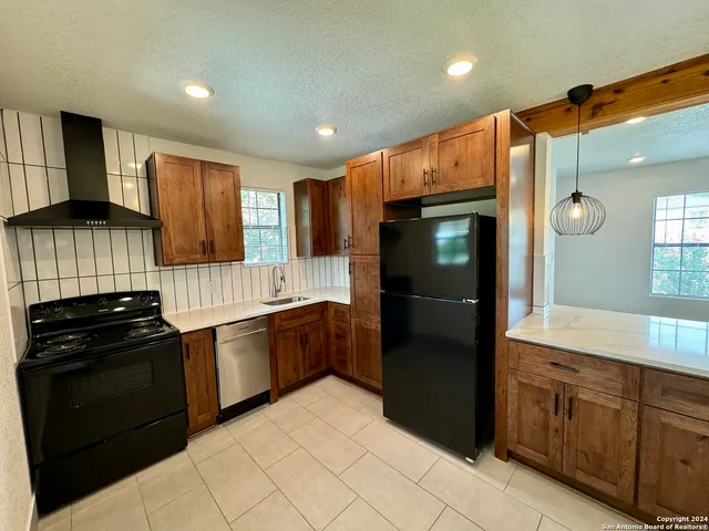 a kitchen with granite countertop stainless steel appliances and wooden cabinets