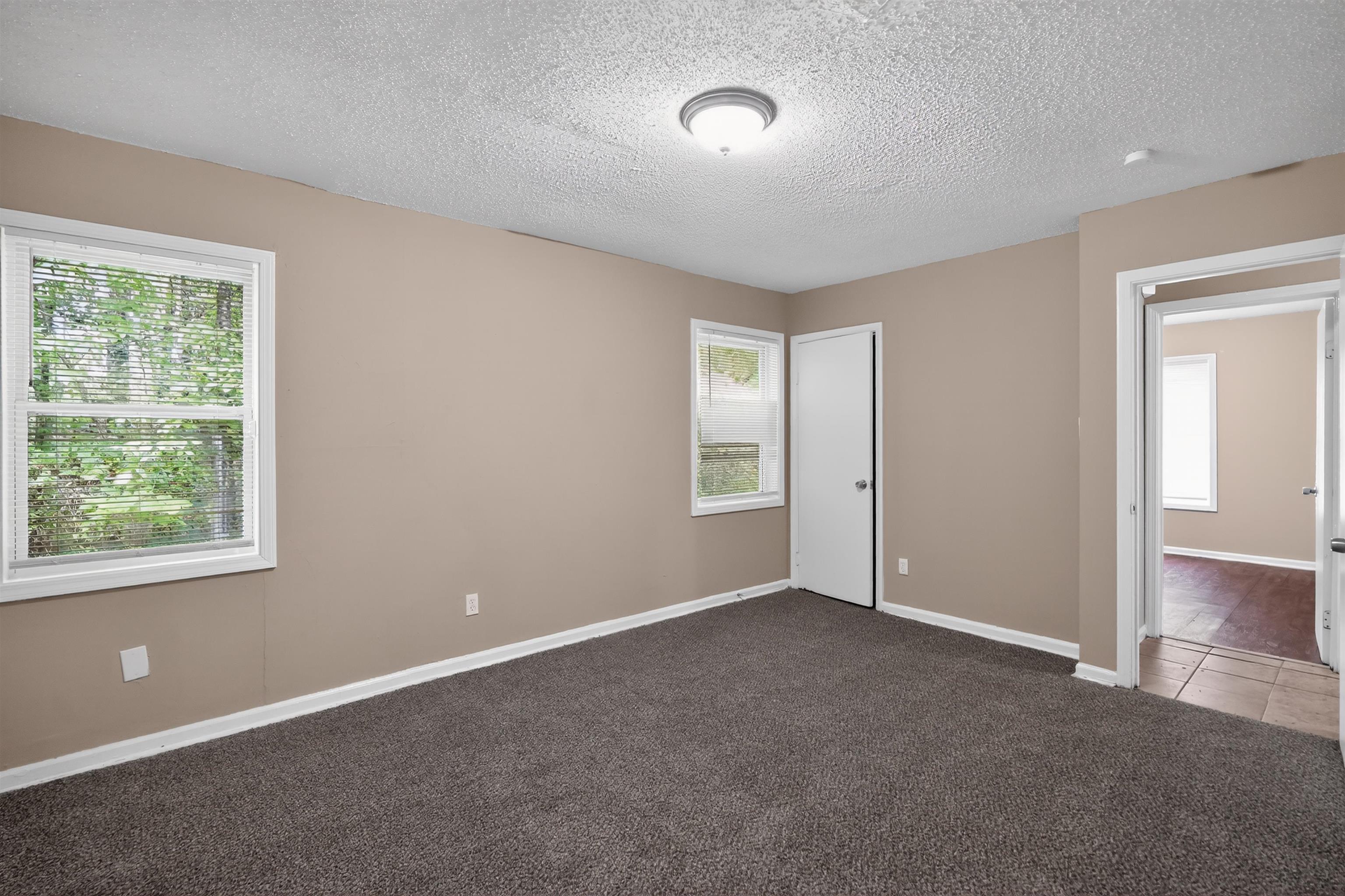 3608 Cane Ridge Drive Memphis, TN 38109 - Photo 22 of 31 Spacious room featuring neutral tone walls, dark carpet flooring, and white trim