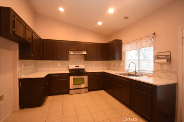 a kitchen with stainless steel appliances granite countertop a sink and stove top oven