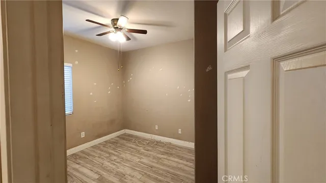 a view of empty room with a ceiling fan and a window