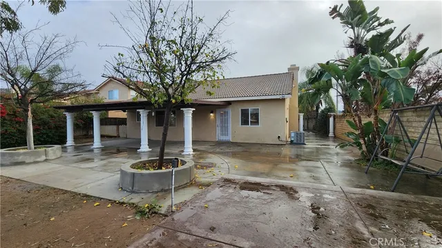 a view of a house with backyard and sitting area