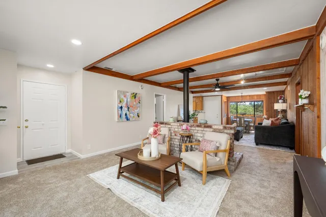 a living room with furniture a chandelier and a large window