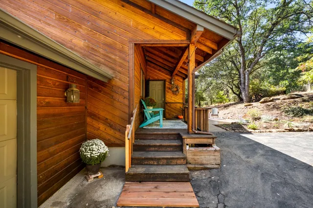 a view of backyard with a table and chairs under an umbrella