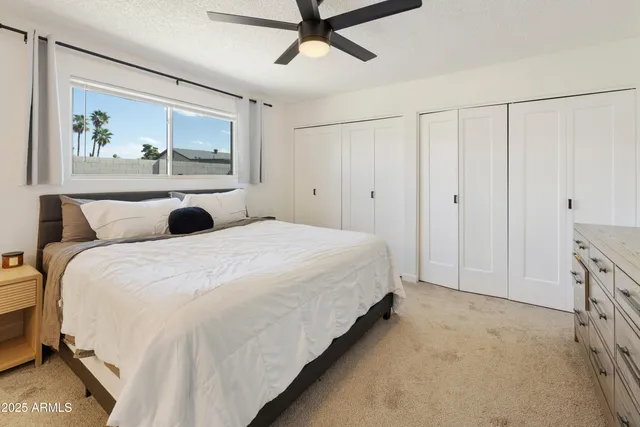 a bedroom with a bed and a painting on the wall