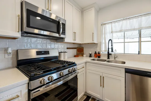 a kitchen with cabinets appliances and a window