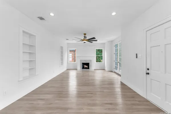 wooden floor fireplace and windows in an empty room