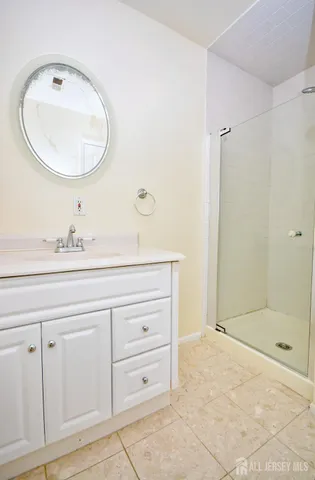 a bathroom with a sink mirror and shower