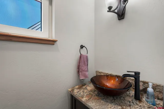 a bathroom with a granite countertop toilet and a mirror