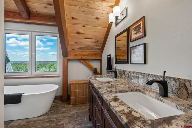 a bathroom with a granite countertop sink and a bathtub