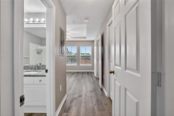 a view of a hallway with wooden floor and a living room