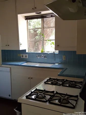 a stove top oven sitting inside of a kitchen