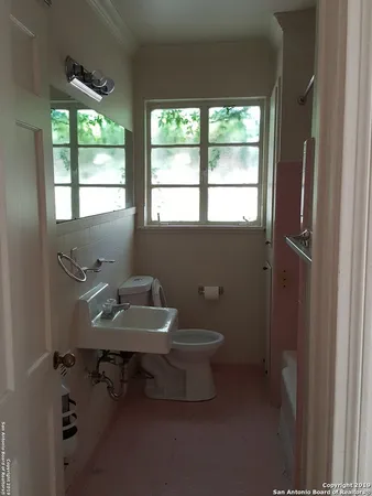 a bathroom with a toilet sink and window