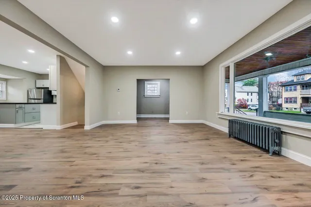 a view of empty room with wooden floor