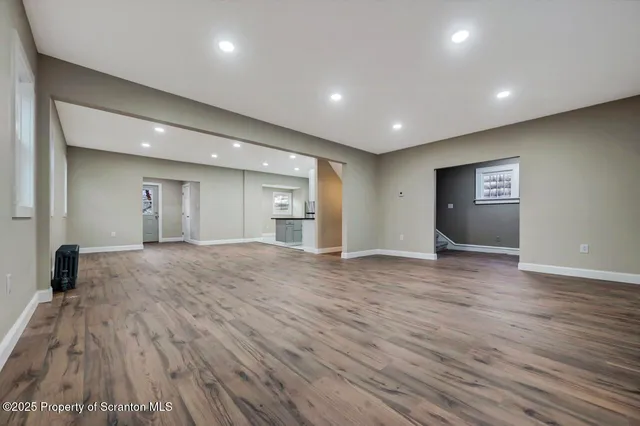 a view of empty room with wooden floor
