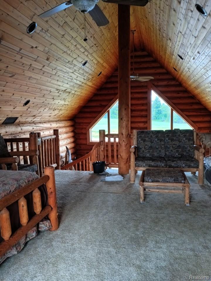 10374 Wilson Road Otisville, MI 48463 - Photo 42 of 99 Carpeted bedroom featuring rustic walls, wooden ceiling, and high vaulted ceiling