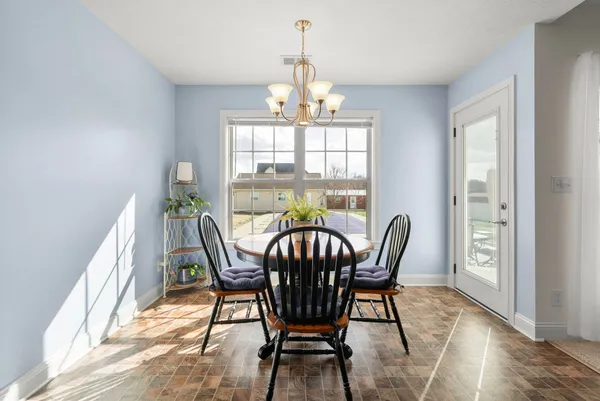 a dining room filled chandelier and wooden floor