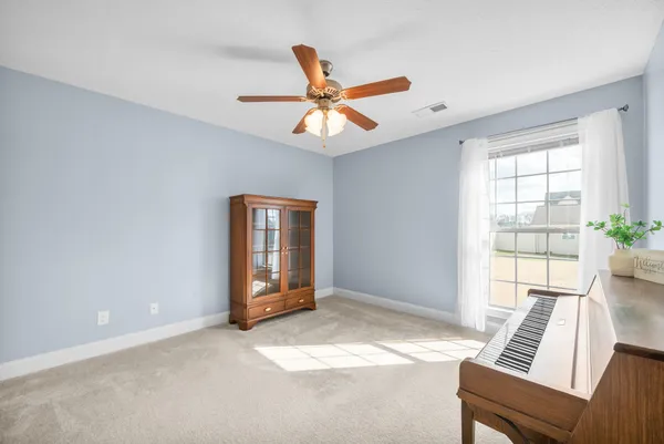 a living room with furniture and a ceiling fan