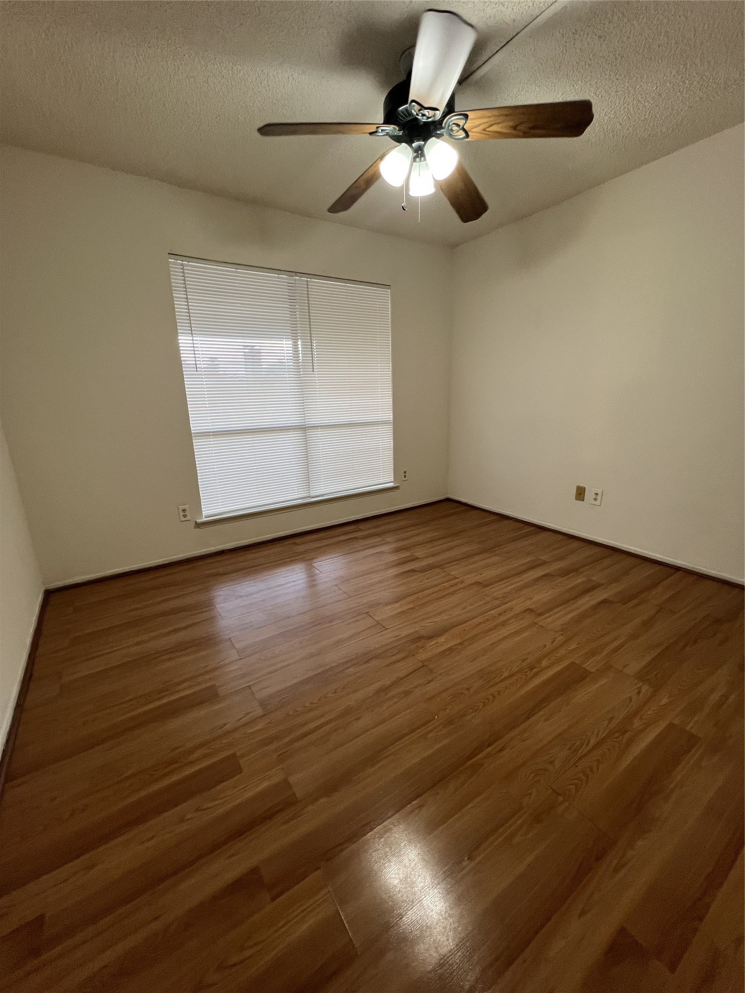 9522 Pagewood Lane, Unit 9522 Houston, TX 77063 - Photo 17 of 22 an empty room with wooden floor fan and windows
