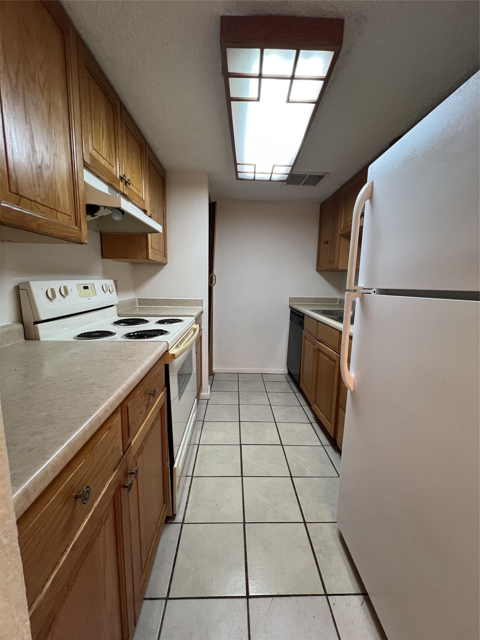 9522 Pagewood Lane, Unit 9522 Houston, TX 77063 - Photo 6 of 22 a kitchen with a stove a refrigerator and a sink