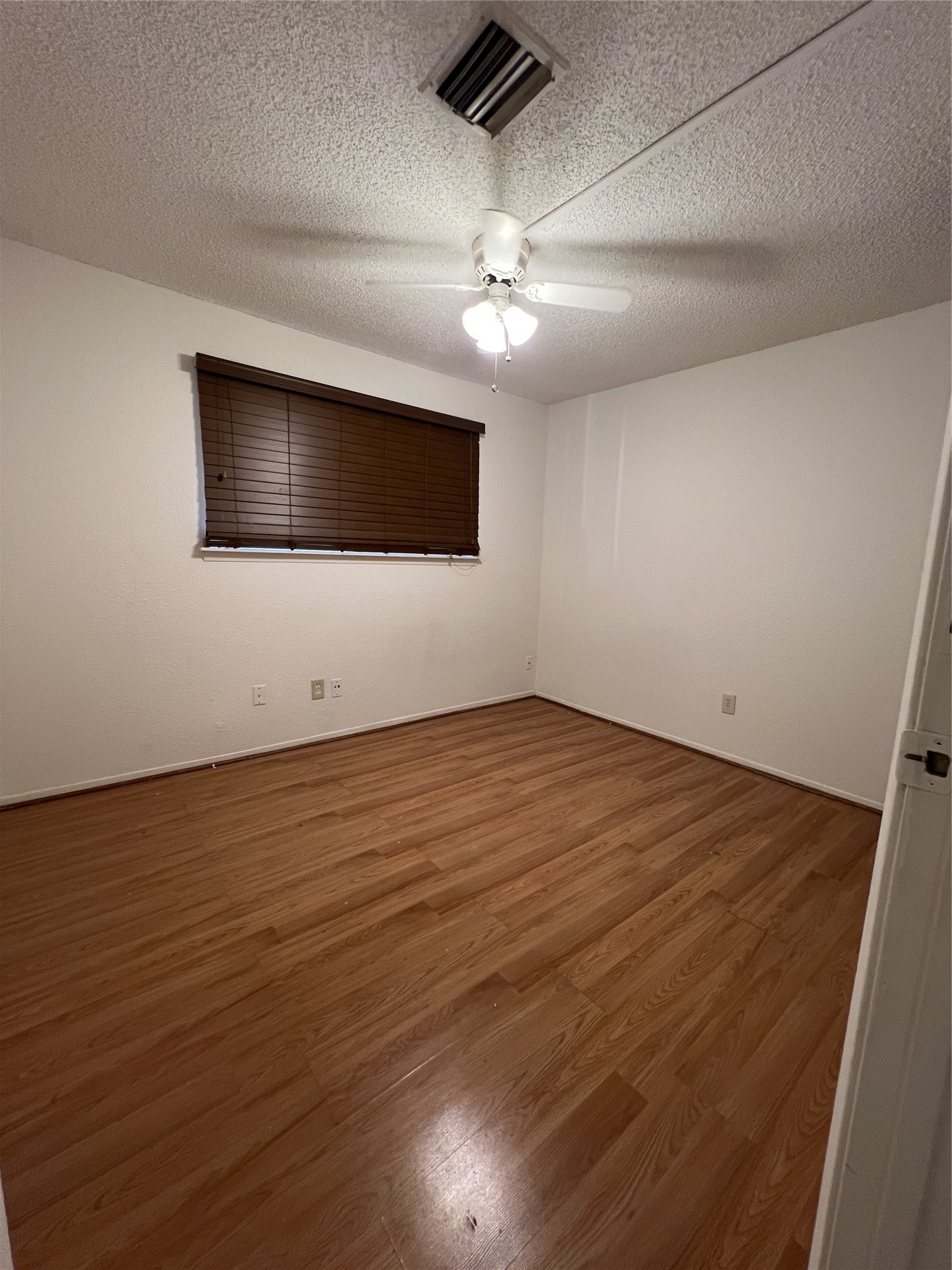 9522 Pagewood Lane, Unit 9522 Houston, TX 77063 - Photo 9 of 22 an empty room with wooden floor and windows