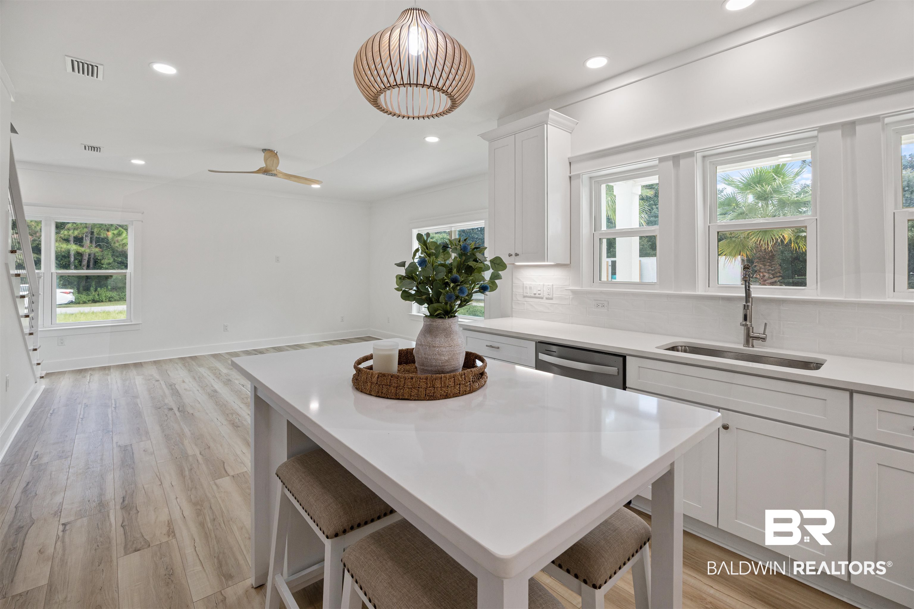 27591 Canal Road Orange Beach, AL 36561 - Photo 10 of 51 Kitchen with white cabinetry, recessed lighting, backsplash, light wood-style flooring, and a breakfast bar area