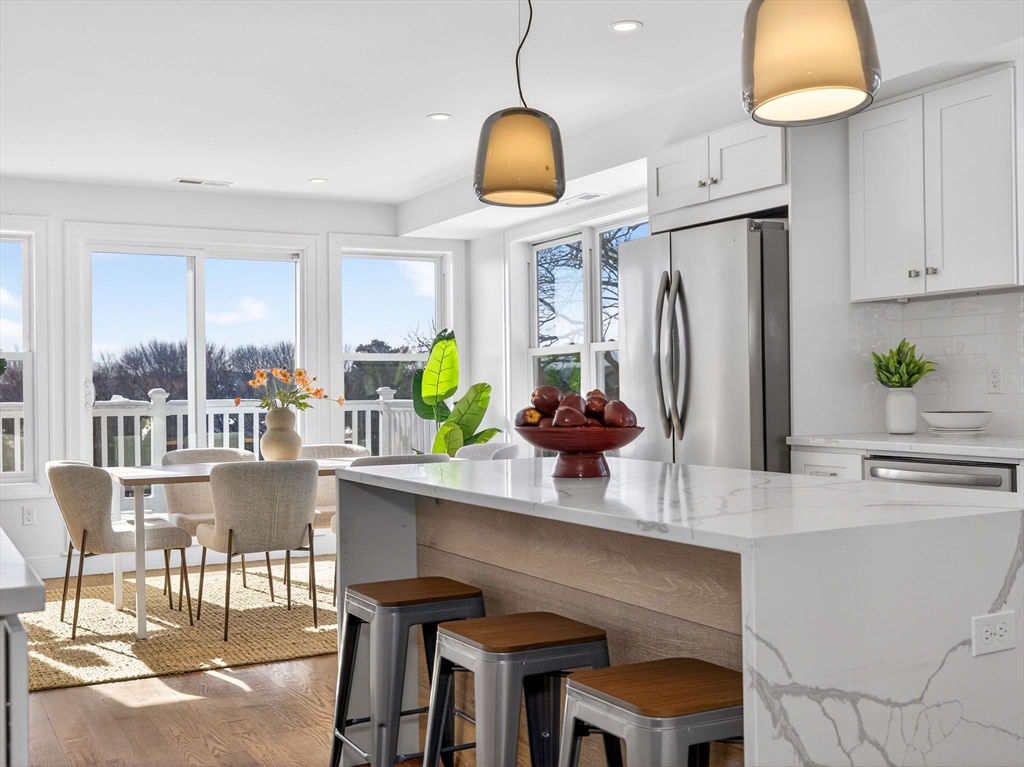 25 Cranston Street, Unit 2 Boston, MA 02130 - Photo 7 of 41 a kitchen with stainless steel appliances a dining table chairs and a refrigerator