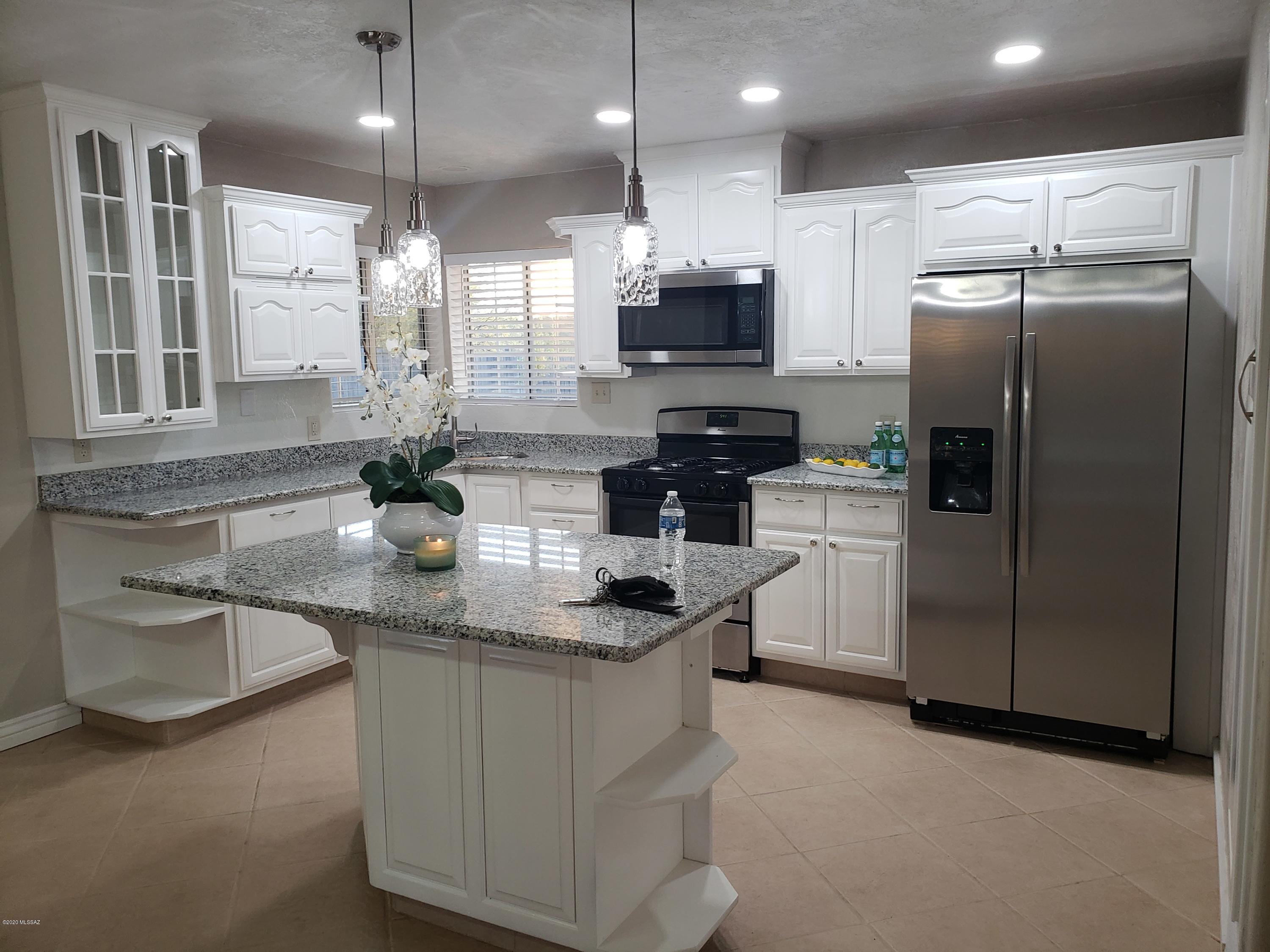 182 Pita Court Rio Rico, AZ 85648 - Photo 32 of 46 a kitchen with stainless steel appliances granite countertop a refrigerator a sink a stove and a microwave