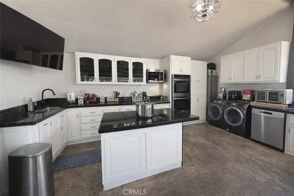 a kitchen with stainless steel appliances kitchen island granite countertop a sink and cabinets