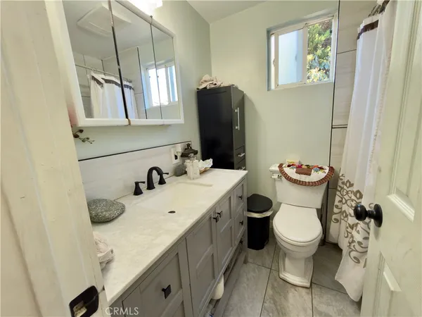 a bathroom with a granite countertop toilet sink and mirror