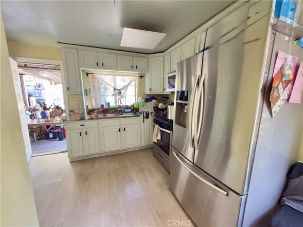 a kitchen with stainless steel appliances a refrigerator sink and cabinets