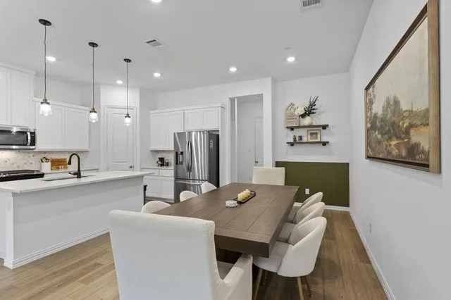 a living room with stainless steel appliances kitchen island granite countertop furniture and a refrigerator
