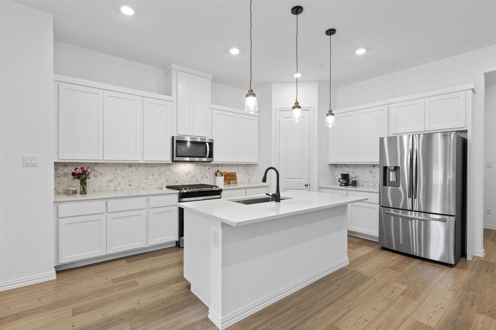 3014 Opera Way Sachse, TX 75048 - Photo 14 of 35 a kitchen with stainless steel appliances granite countertop a sink stove and refrigerator