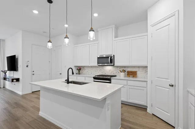 a kitchen that has a lot of cabinets and wooden floor