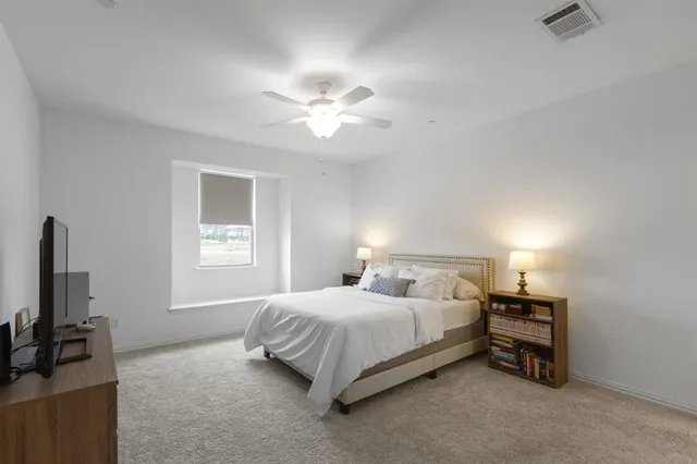 a bedroom with a bed and a flat tv screen on a dresser