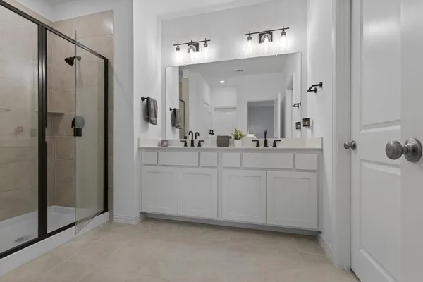 a bathroom with a double vanity sink mirror and shower